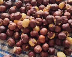 Step <h4><b>Una vez termine el proceso de tostado, ponemos las avellanas en un paño y las refregamos entre si para poder quitarles la piel. (No hay ningún problema si se nos cuela algo de piel.</b></h4> illustration