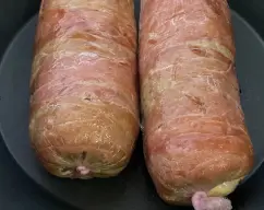 Step <p>Ponga las lonchas de beicon en vertical formando un rectángulo sobre una doble capa de film transparente. Extienda la mezcla de carne encima dejando libre 3-4 cm del lado superior. Coloque las lonchas de jamón sobre la carne y las de queso sobre el jamón. Enrolle todo junto como si fuera un brazo de gitano y envuélvalo todo con el film transparente, apretando muy bien. Colóquelo en el centro del recipiente Varoma y con un tenedor pinche el film transparente varias veces. Tape el Varoma y reserve. </p> illustration